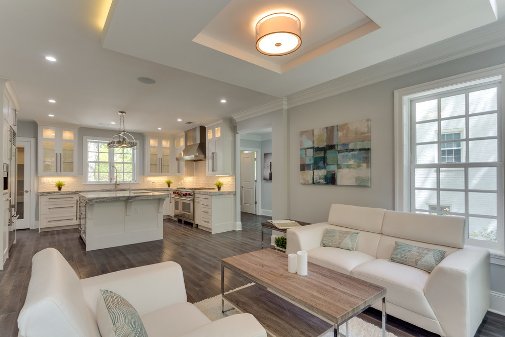 Inspiration for a large transitional l-shaped medium tone wood floor open concept kitchen remodel in DC Metro with a double-bowl sink, shaker cabinets, white cabinets, marble countertops, white backsplash, porcelain backsplash, stainless steel appliances and an island