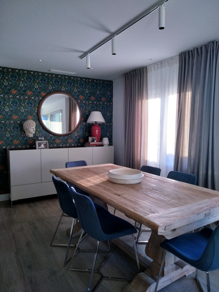 Large contemporary kitchen/dining combo in Alicante-Costa Blanca with blue walls, medium hardwood floors, a hanging fireplace and a metal fireplace surround.