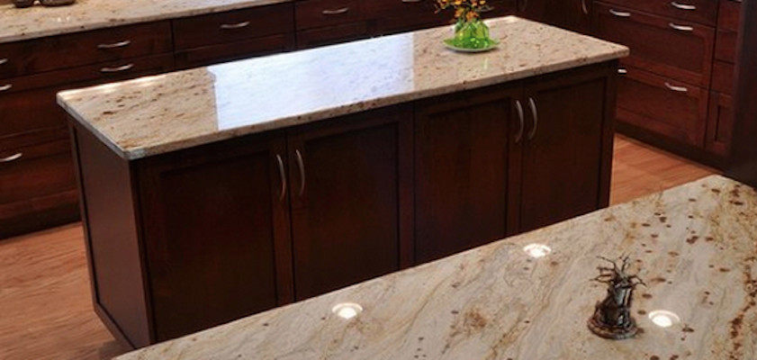 Eat-in kitchen - light wood floor eat-in kitchen idea with recessed-panel cabinets, dark wood cabinets, granite countertops and an island