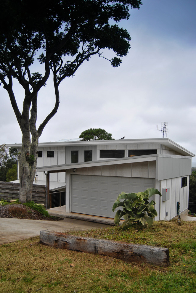 Photo of a mid-sized contemporary two-storey grey exterior in Gold Coast - Tweed with concrete fiberboard siding and a shed roof.