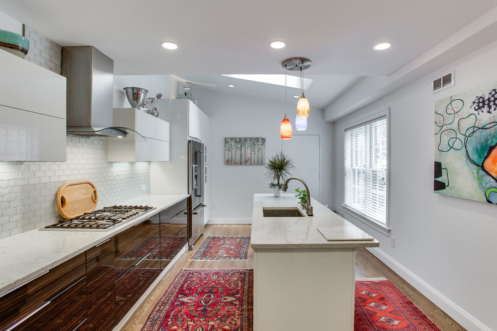 Mid-sized modern kitchen in DC Metro with an undermount sink, flat-panel cabinets, white splashback, stainless steel appliances and medium hardwood floors.