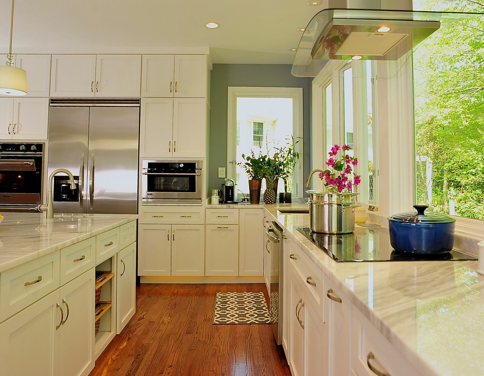 Large transitional u-shaped medium tone wood floor kitchen photo in DC Metro with an undermount sink, shaker cabinets, white cabinets, granite countertops, stainless steel appliances and an island