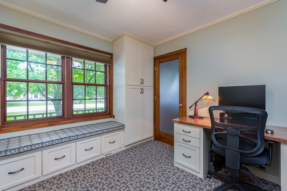 This is an example of a mid-sized transitional study room in Milwaukee with a freestanding desk, white walls, carpet, no fireplace and grey floor.