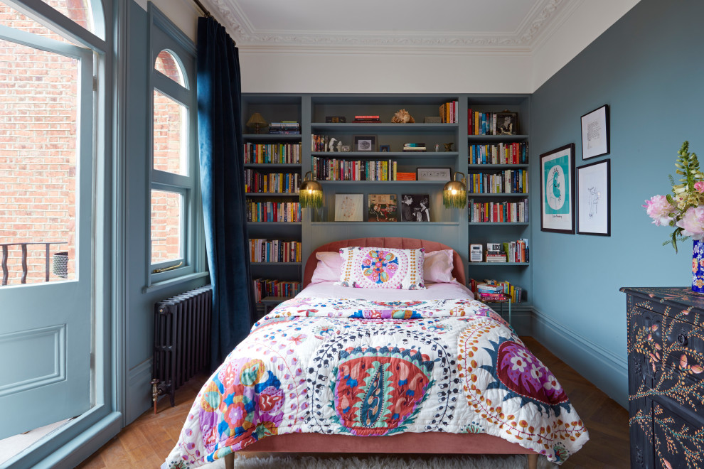This is an example of a traditional bedroom in London with multi-coloured walls, medium hardwood floors and no fireplace.