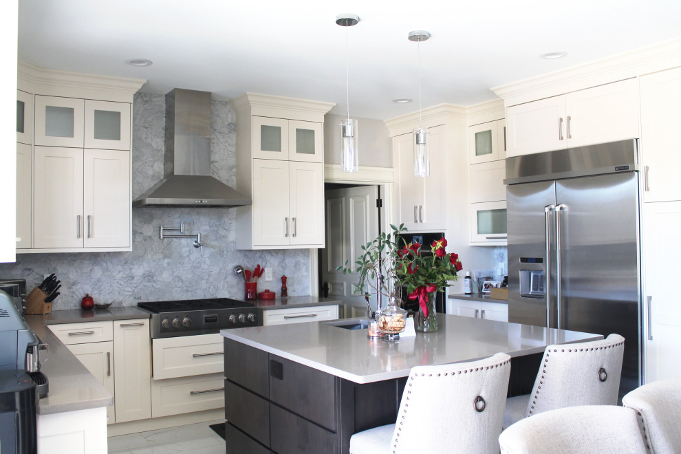 Example of a large transitional u-shaped eat-in kitchen design with shaker cabinets, white cabinets, quartz countertops, gray backsplash, stainless steel appliances, an island and gray countertops
