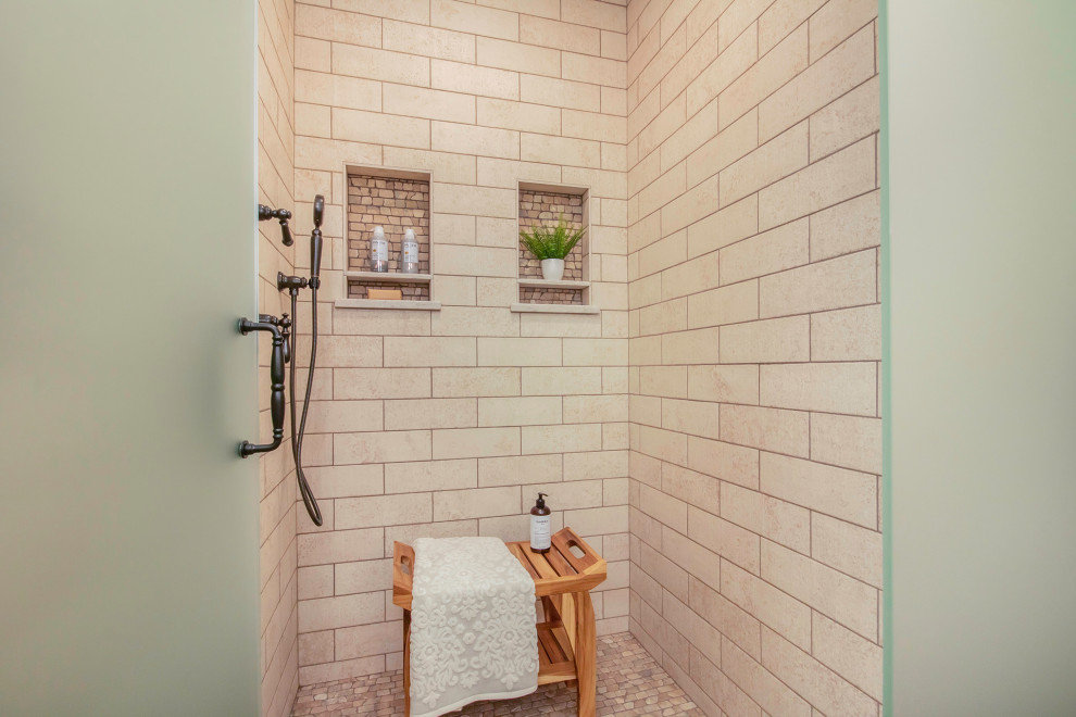 Inspiration for a transitional bathroom in Grand Rapids with an alcove shower, beige tile, travertine, pebble tile floors and a hinged shower door.