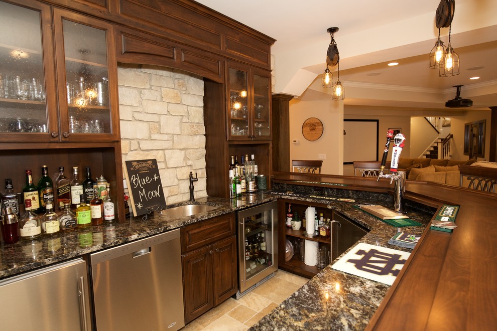 Photo of a large arts and crafts u-shaped seated home bar in Chicago with an undermount sink, raised-panel cabinets, medium wood cabinets, granite benchtops, beige splashback, stone tile splashback and travertine floors.