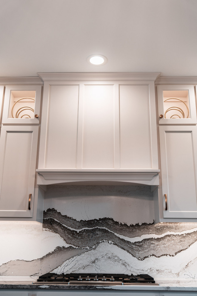 Large transitional l-shaped medium tone wood floor and brown floor open concept kitchen photo with an undermount sink, flat-panel cabinets, white cabinets, quartz countertops, multicolored backsplash, quartz backsplash, black appliances, an island and multicolored countertops