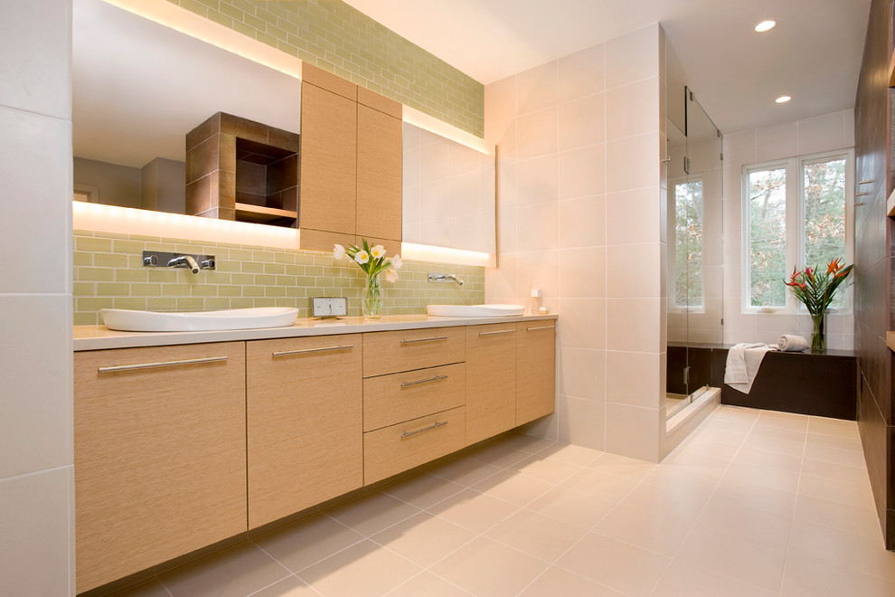 Photo of a large modern master bathroom in Boston with flat-panel cabinets, light wood cabinets, an alcove tub, green tile, subway tile, beige walls, cement tiles, a vessel sink, engineered quartz benchtops, beige floor, beige benchtops, an alcove shower and a hinged shower door.