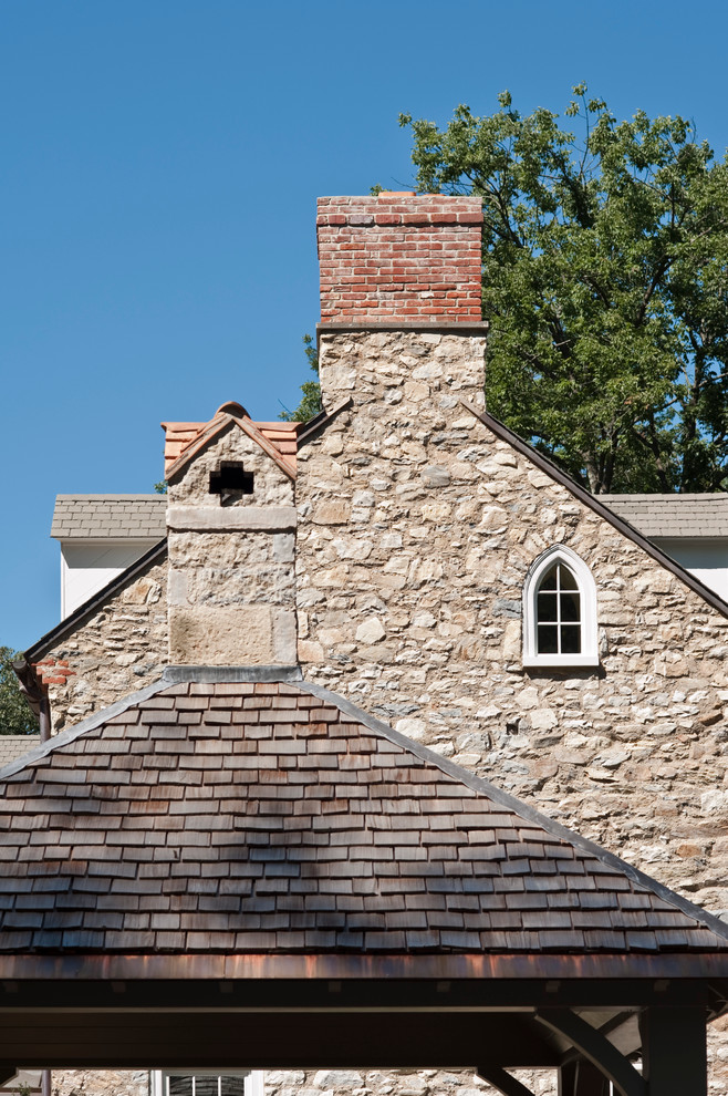 This is an example of a country three-storey exterior in Philadelphia with stone veneer and a gable roof.