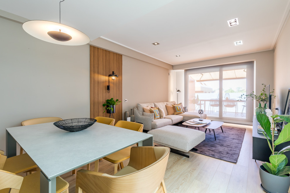 Mittelgroßes, Abgetrenntes Modernes Wohnzimmer in grau-weiß mit grauer Wandfarbe, hellem Holzboden, freistehendem TV, braunem Boden und Holzwänden in Madrid