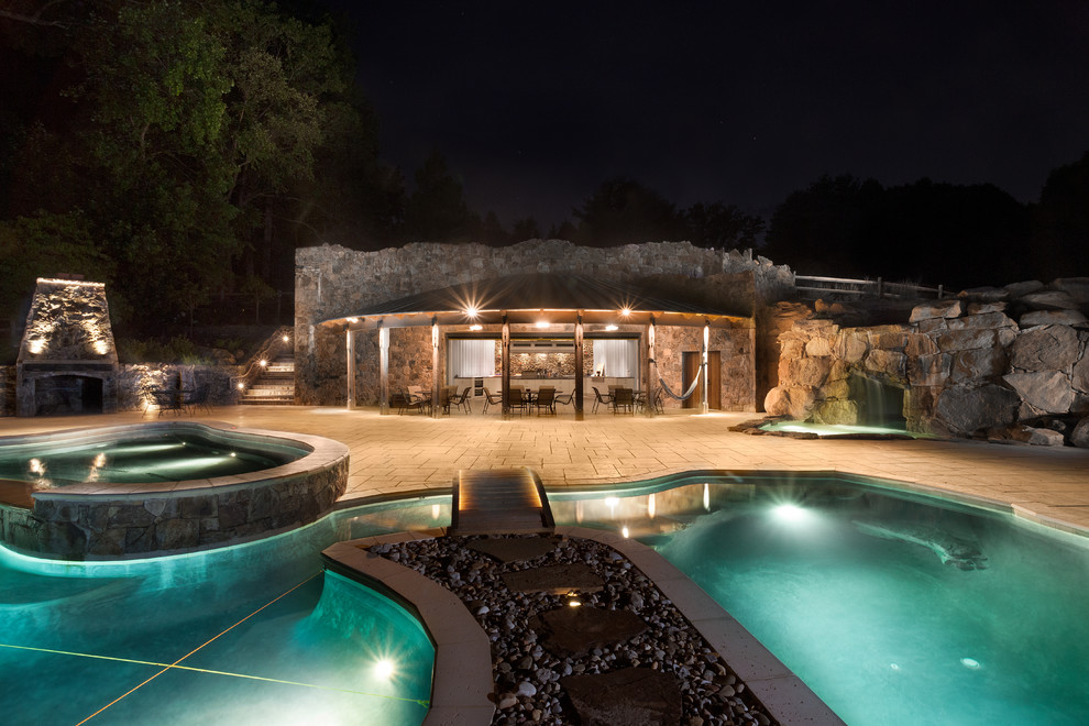 Large modern side yard custom-shaped natural pool in DC Metro with a pool house and natural stone pavers.