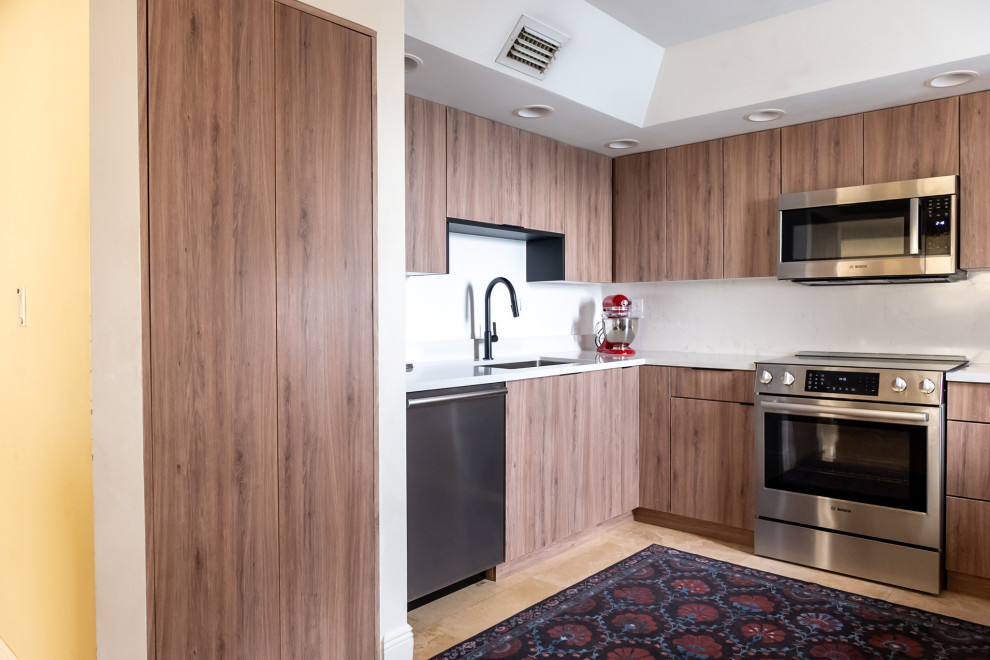 Cette image montre une arrière-cuisine minimaliste en U et bois clair de taille moyenne avec un plan de travail en quartz modifié.