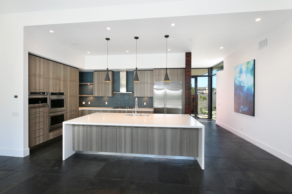 Inspiration for a contemporary l-shaped kitchen in Orange County with an undermount sink, flat-panel cabinets, medium wood cabinets, blue splashback, glass tile splashback, stainless steel appliances, slate floors and with island.