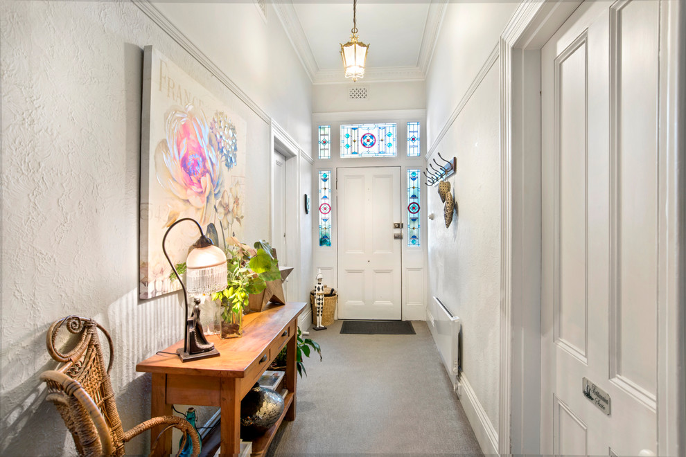 Design ideas for an eclectic entry hall in Melbourne with white walls, a single front door, a white front door and grey floor.
