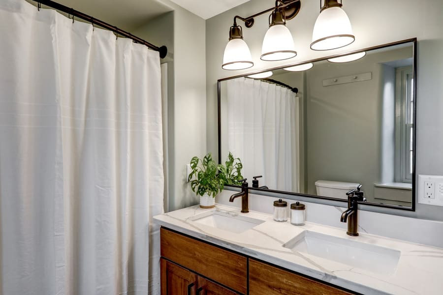 Idéer för ett mellanstort lantligt vit en-suite badrum, med luckor med infälld panel, bruna skåp, en dusch/badkar-kombination, en toalettstol med separat cisternkåpa, grå väggar, mellanmörkt trägolv, ett undermonterad handfat, bänkskiva i kvarts och flerfärgat golv