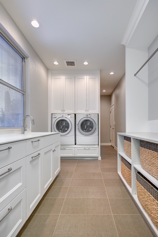 Mid-sized transitional galley utility room in Sacramento with a farmhouse sink, recessed-panel cabinets, white cabinets, quartz benchtops, white splashback, porcelain splashback, grey walls, porcelain floors and a side-by-side washer and dryer.
