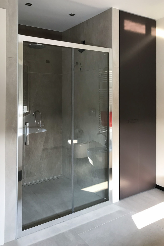 Photo of a mid-sized contemporary 3/4 bathroom in Milan with flat-panel cabinets, orange cabinets, a freestanding tub, a curbless shower, a two-piece toilet, gray tile, porcelain tile, white walls, porcelain floors, a vessel sink, laminate benchtops, grey floor, a sliding shower screen and brown benchtops.