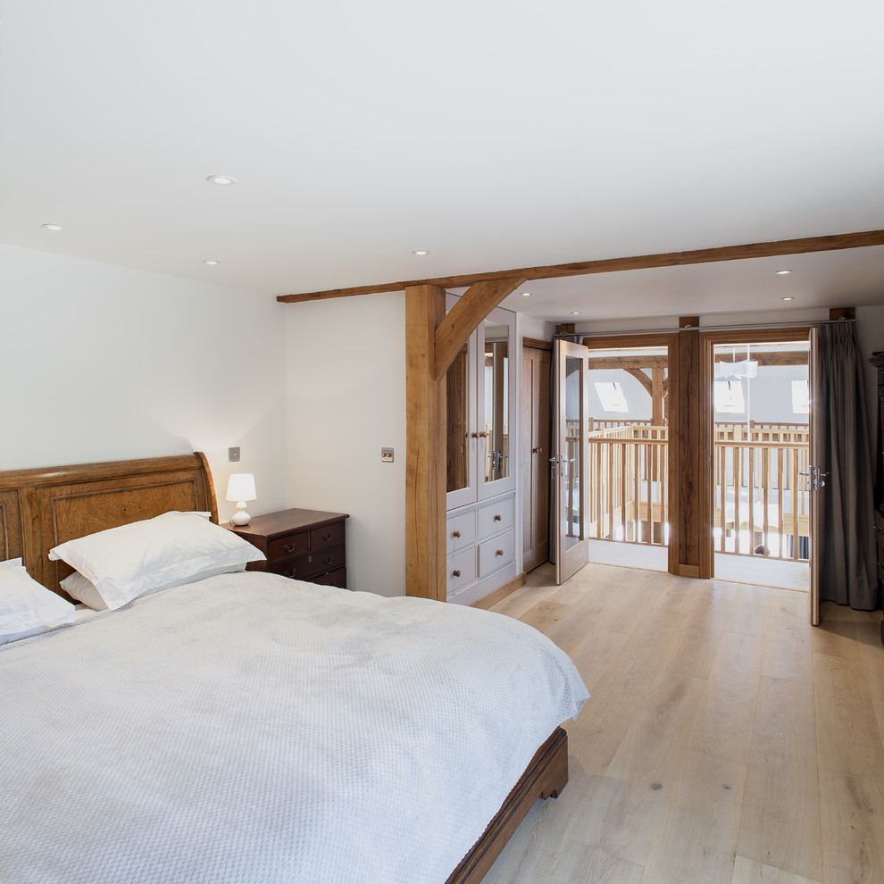 Design ideas for a mid-sized arts and crafts master bedroom in Sussex with white walls, ceramic floors and beige floor.