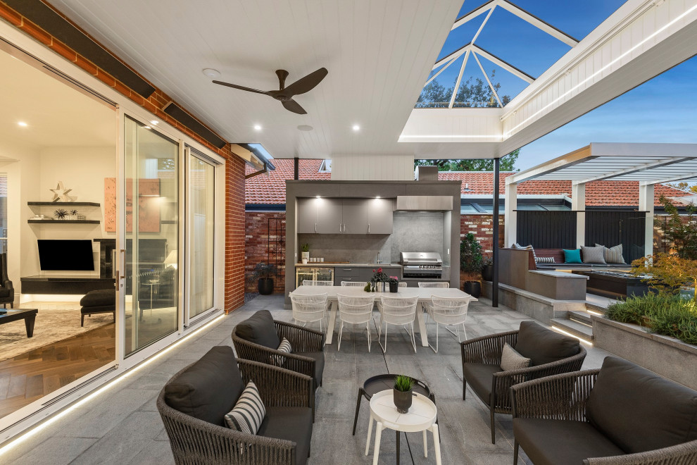 Photo of a mid-sized traditional backyard patio in Melbourne with concrete pavers, a gazebo/cabana and an outdoor kitchen.