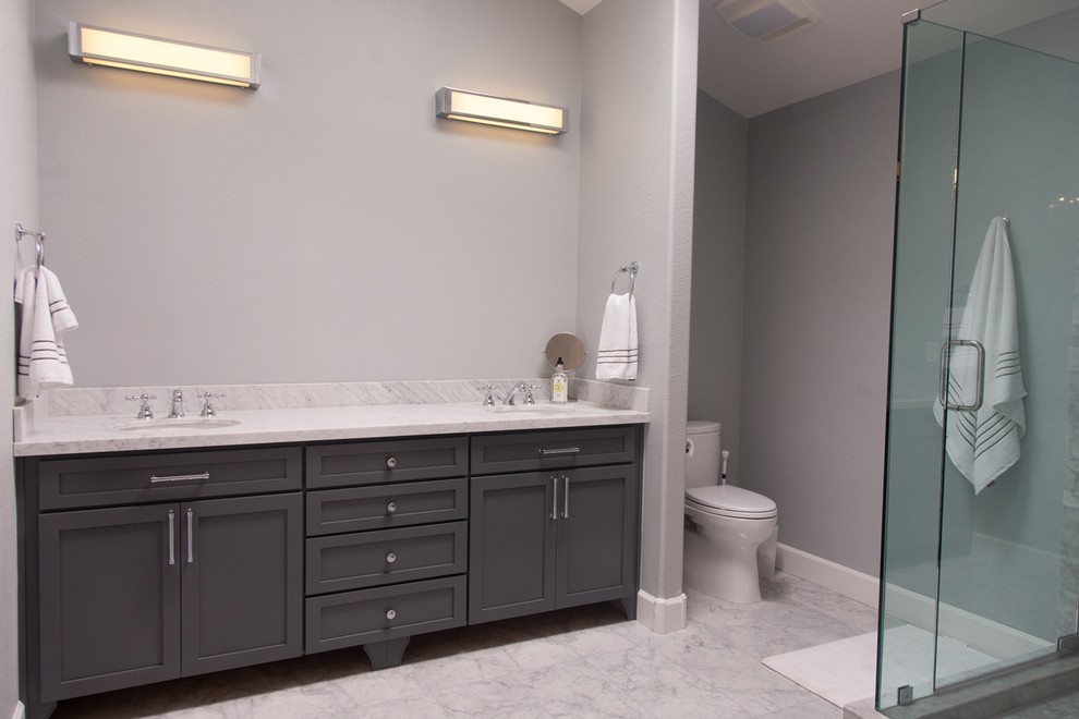 Corner shower - large contemporary 3/4 gray tile corner shower idea in Phoenix with an undermount sink, recessed-panel cabinets, gray cabinets, a one-piece toilet and gray walls