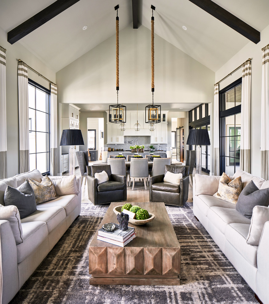This is an example of a transitional open concept living room in Austin with grey walls, light hardwood floors, a standard fireplace and a stone fireplace surround.