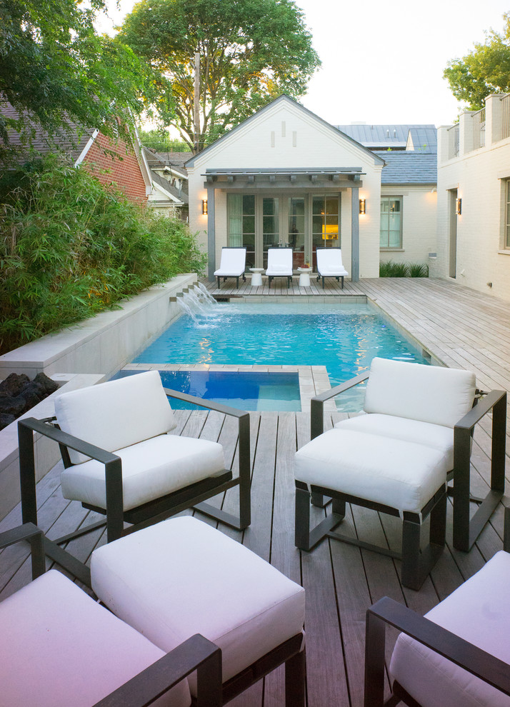 Small transitional backyard rectangular pool in Dallas with a water feature and decking.