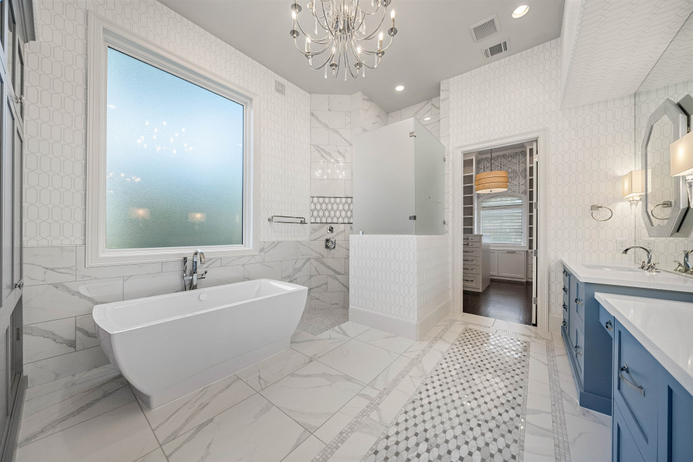 Стильный дизайн: большая главная ванная комната в стиле неоклассика (современная классика) с синими фасадами, отдельно стоящей ванной, угловым душем, разноцветной плиткой, белыми стенами, врезной раковиной, столешницей из искусственного кварца, разноцветным полом, открытым душем, белой столешницей, тумбой под две раковины, встроенной тумбой, обоями на стенах, фасадами с утопленной филенкой, керамогранитной плиткой и полом из керамогранита - последний тренд