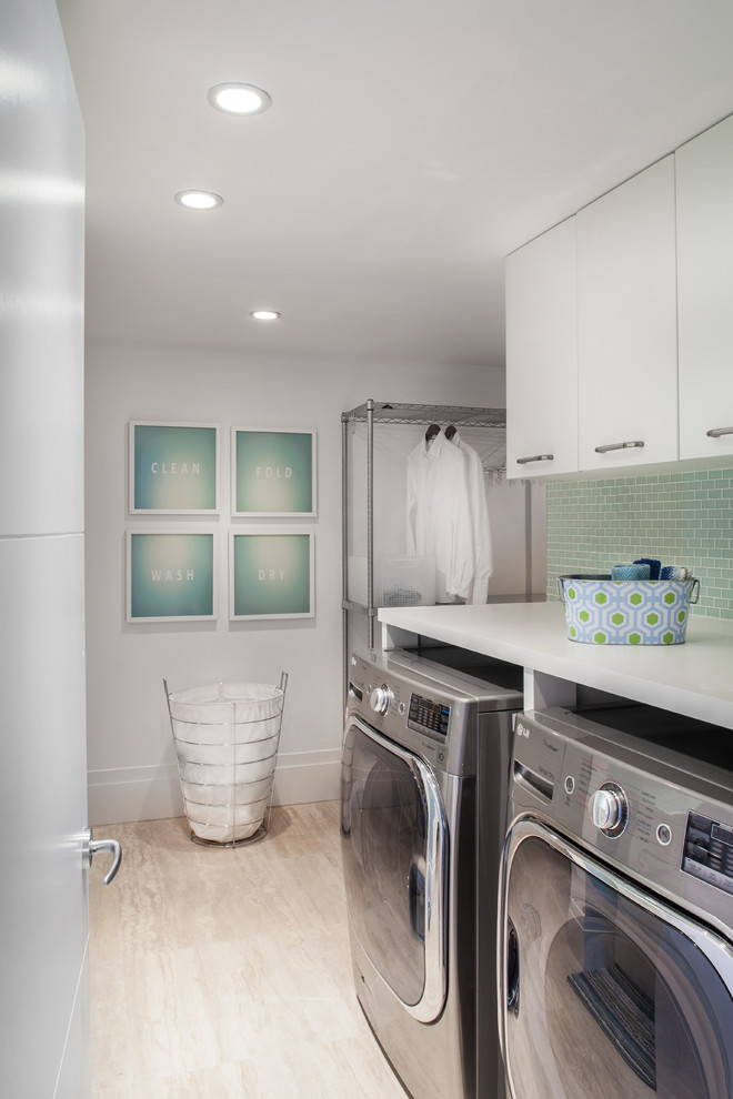 Inspiration for a small contemporary single-wall utility room in Miami with flat-panel cabinets, white cabinets, white walls, light hardwood floors and a side-by-side washer and dryer.