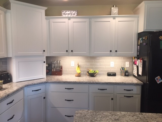 Example of a mid-sized transitional l-shaped eat-in kitchen design with shaker cabinets, white cabinets and an island