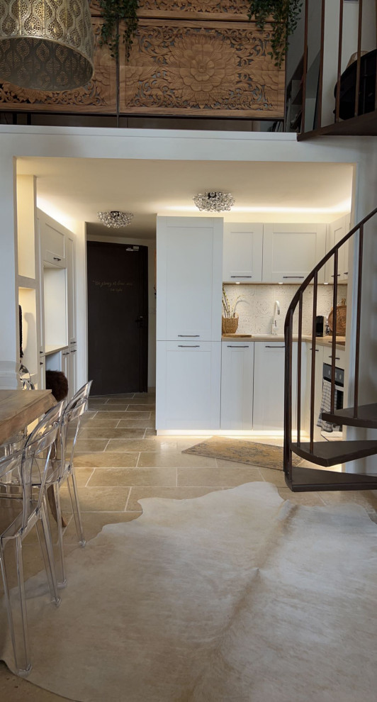Small eclectic l-shaped open plan kitchen in Other with a drop-in sink, shaker cabinets, white cabinets, quartz benchtops, white splashback, porcelain splashback, white appliances, travertine floors, no island, beige floor, beige benchtop and exposed beam.