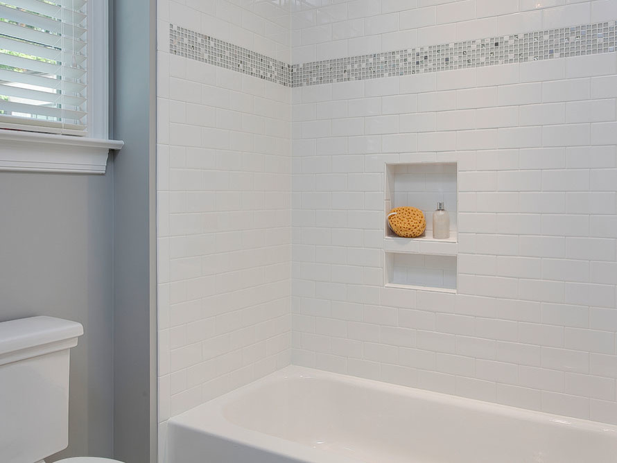 This is an example of a small modern bathroom in Raleigh with white cabinets and white tile.