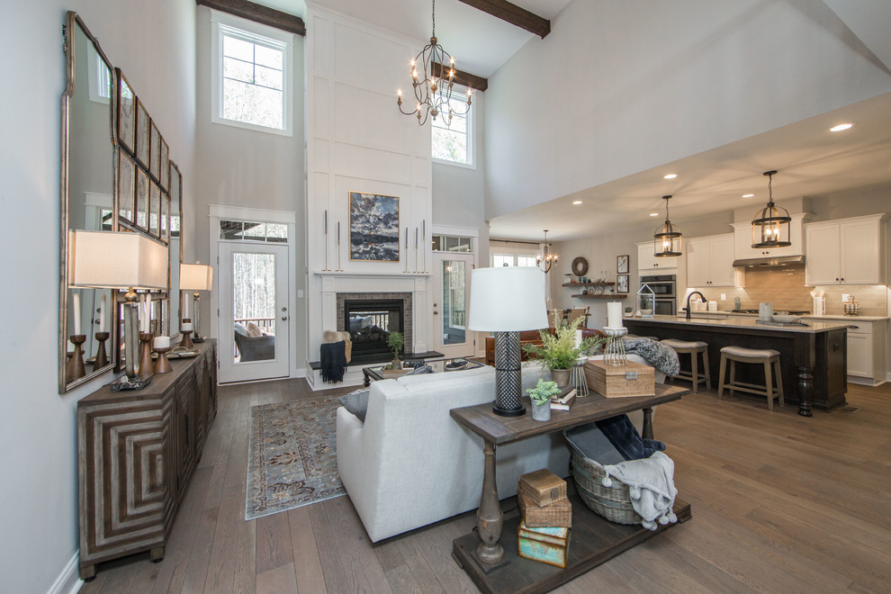 Inspiration for an expansive arts and crafts loft-style family room in Richmond with beige walls, medium hardwood floors, a two-sided fireplace, a tile fireplace surround, no tv and brown floor.