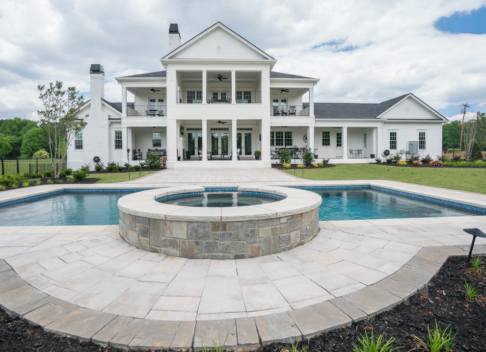 Inspiration for a large traditional backyard rectangular lap pool in Other with a hot tub and concrete pavers.
