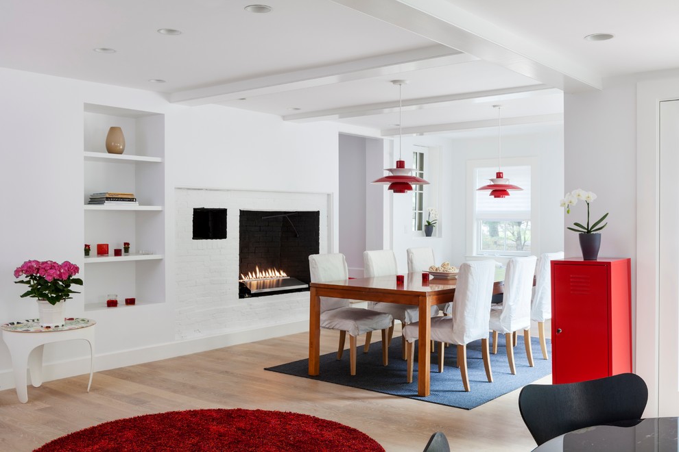 Photo of a large traditional kitchen/dining combo in Boston with white walls, light hardwood floors, a standard fireplace and a brick fireplace surround.