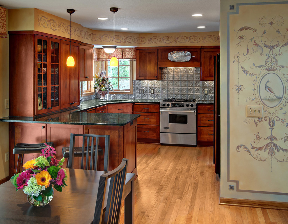 Photo of a traditional u-shaped kitchen in Minneapolis with granite benchtops, metallic splashback, metal splashback and stainless steel appliances.