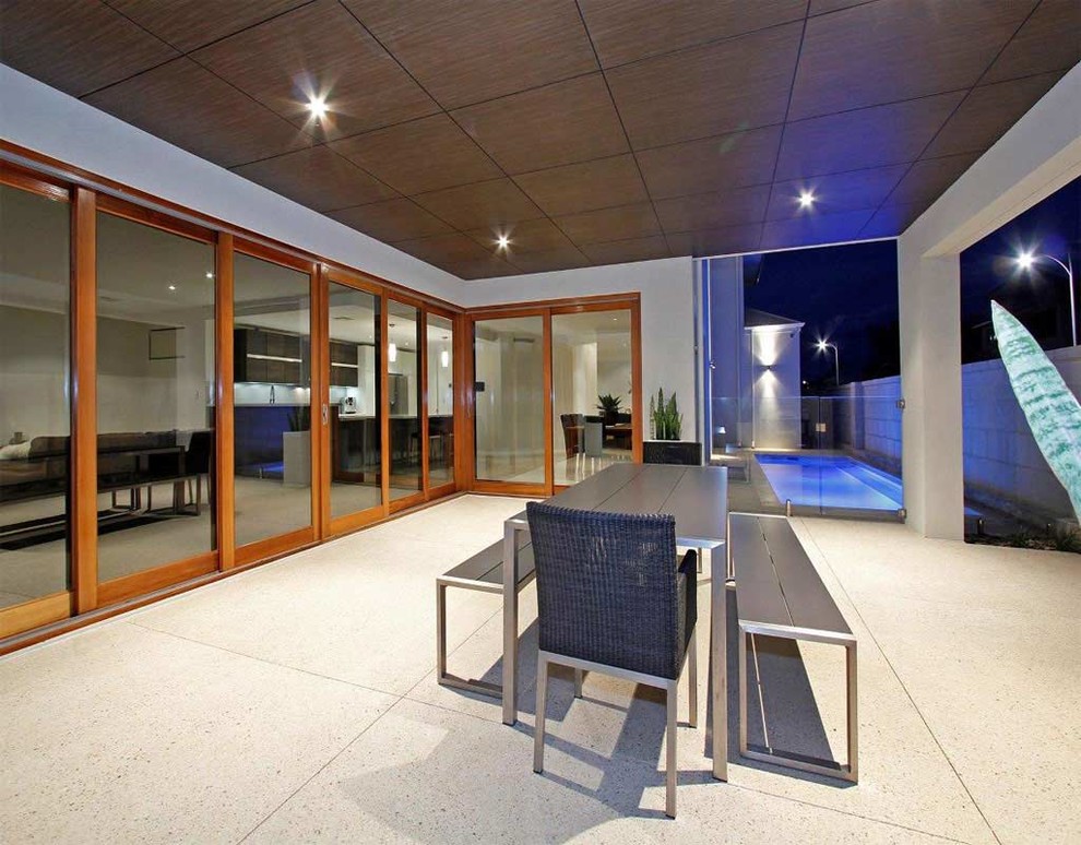 This is an example of a mid-sized contemporary side yard patio in Perth with a roof extension.