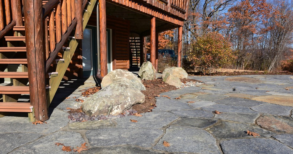 Inspiration for a large rustic backyard stone patio remodel in Boston with no cover