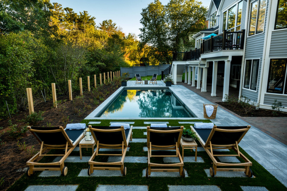 This is an example of a small contemporary backyard rectangular lap pool in Boston with with privacy feature and concrete slab.