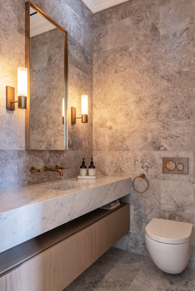 This is an example of a contemporary powder room in Sydney with beaded inset cabinets, medium wood cabinets, a wall-mount toilet, gray tile, an integrated sink, grey floor and grey benchtops.