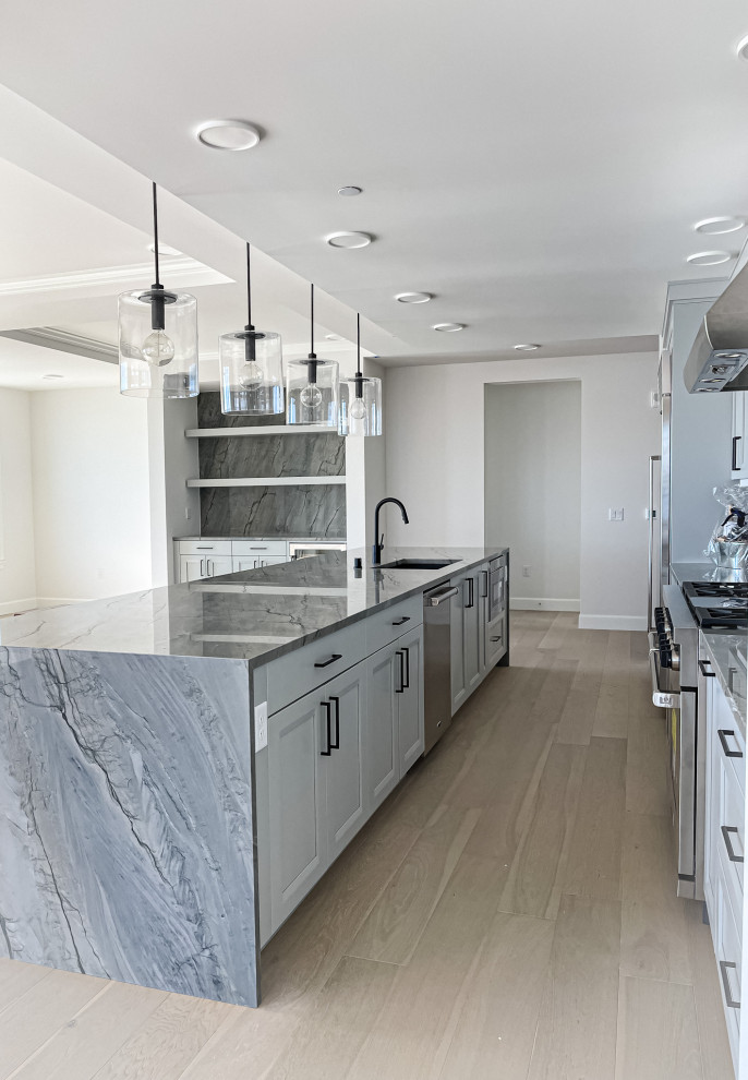 This is an example of a large modern kitchen in Seattle with a double-bowl sink, quartz worktops, blue splashback, an island and blue worktops.