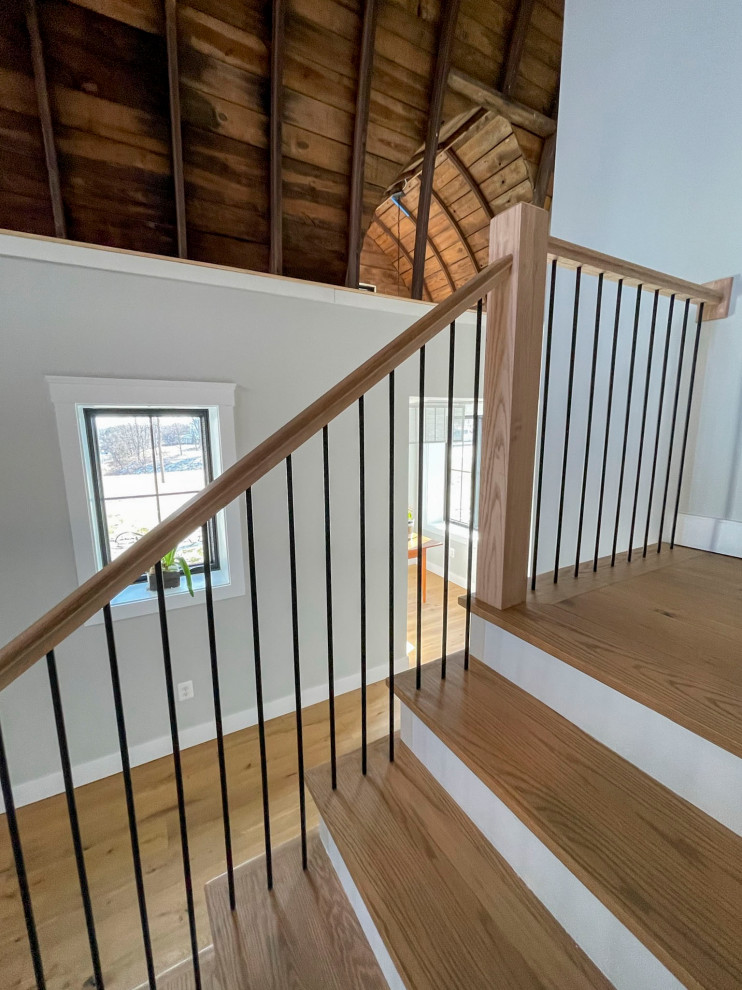 This is an example of an expansive transitional wood straight staircase in DC Metro with wood risers and mixed railing.