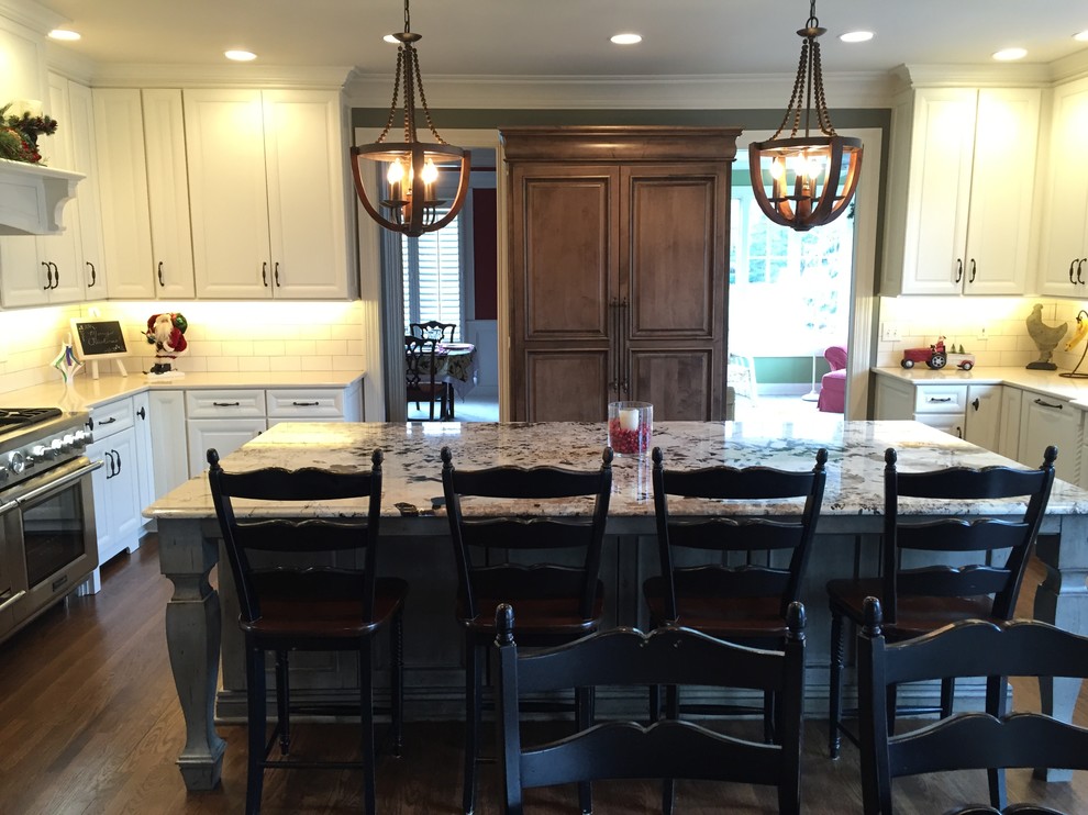 Eat-in kitchen - large transitional u-shaped dark wood floor eat-in kitchen idea in Indianapolis with an undermount sink, recessed-panel cabinets, white cabinets, granite countertops, white backsplash, subway tile backsplash, stainless steel appliances and an island