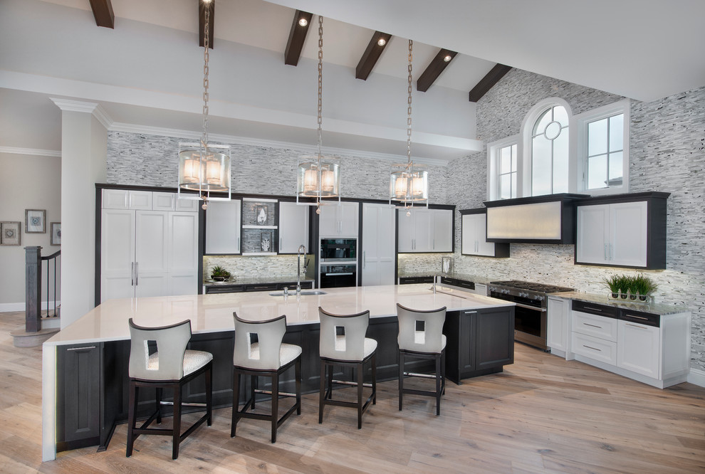 This is an example of an expansive modern l-shaped open plan kitchen in Miami with a farmhouse sink, white cabinets, onyx benchtops, grey splashback, stone tile splashback, panelled appliances, medium hardwood floors and with island.