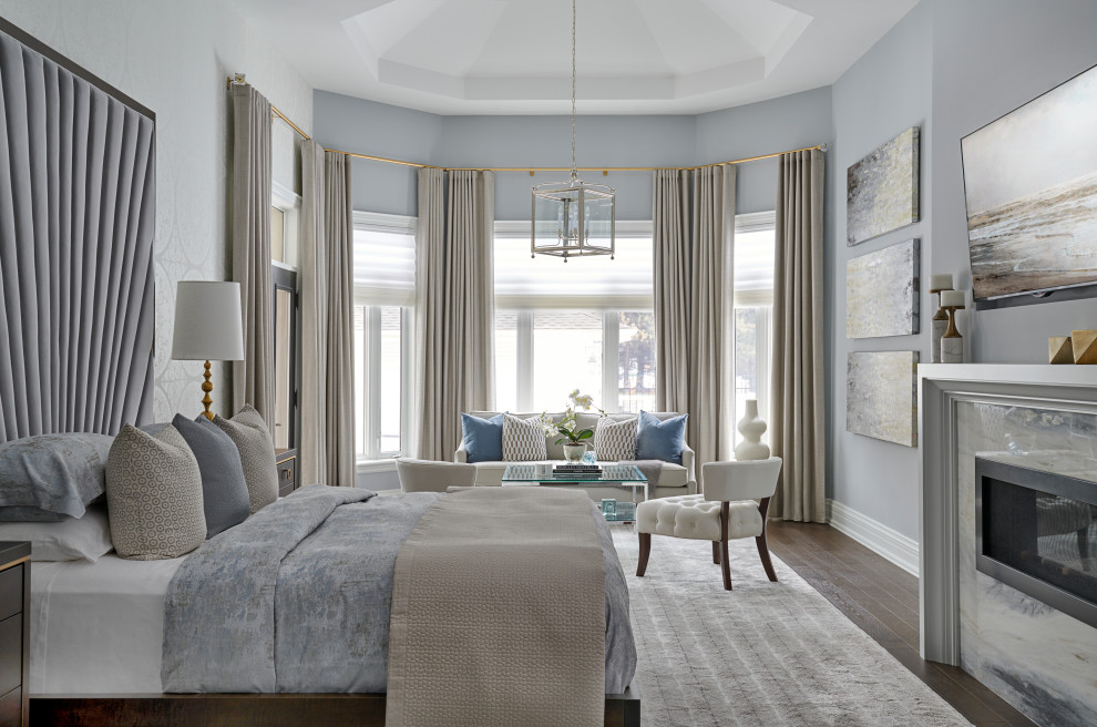 Klassisches Schlafzimmer mit grauer Wandfarbe, dunklem Holzboden, Gaskamin, Kaminumrandung aus Stein, braunem Boden, eingelassener Decke und Tapetenwänden in Toronto