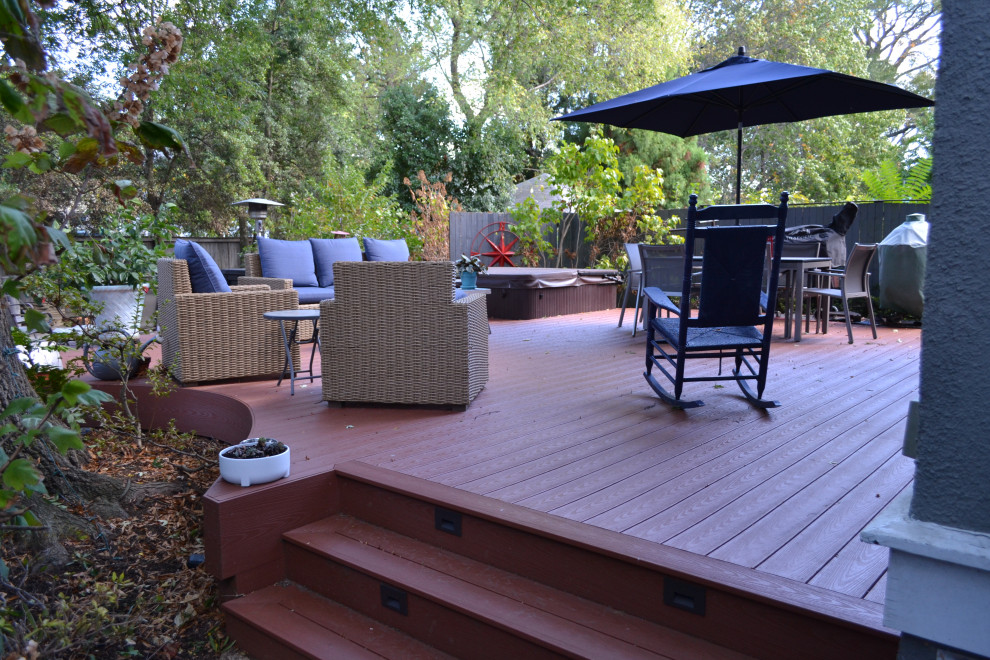 Example of a mid-sized transitional backyard stone deck design in Baltimore with a fire pit and no cover