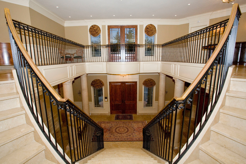 Photo of an expansive mediterranean foyer in Other with brown walls, granite floors, a double front door and a dark wood front door.