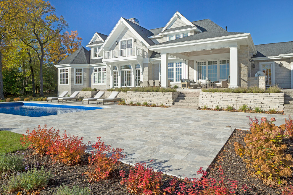 Beach style backyard rectangular pool in Minneapolis with a pool house and natural stone pavers.