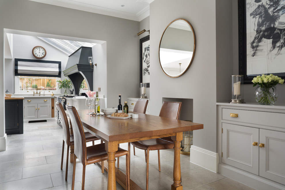 This is an example of a mid-sized transitional kitchen/dining combo in London with grey walls and grey floor.