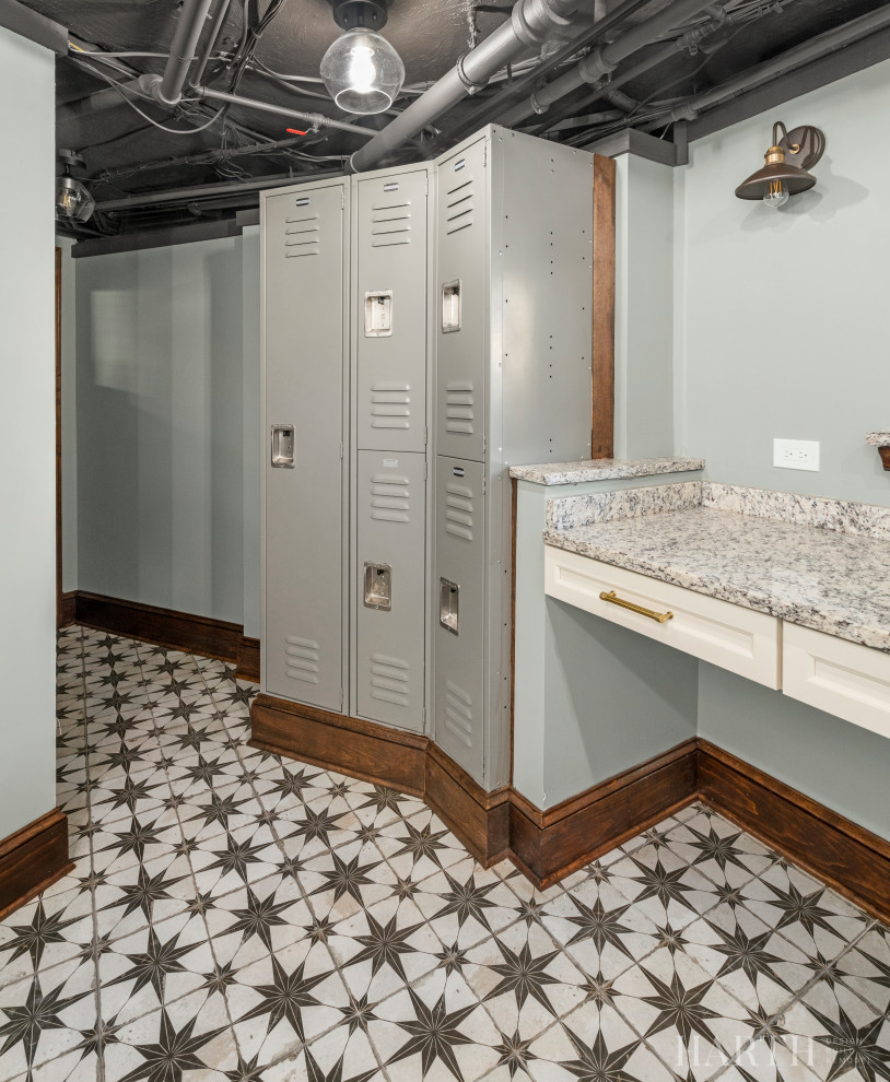 Inspiration for a mid-sized eclectic galley utility room in Philadelphia with a farmhouse sink, recessed-panel cabinets, beige cabinets, granite benchtops, multi-coloured splashback, granite splashback, grey walls, concrete floors, a side-by-side washer and dryer, multi-coloured floor, multi-coloured benchtop and exposed beam.